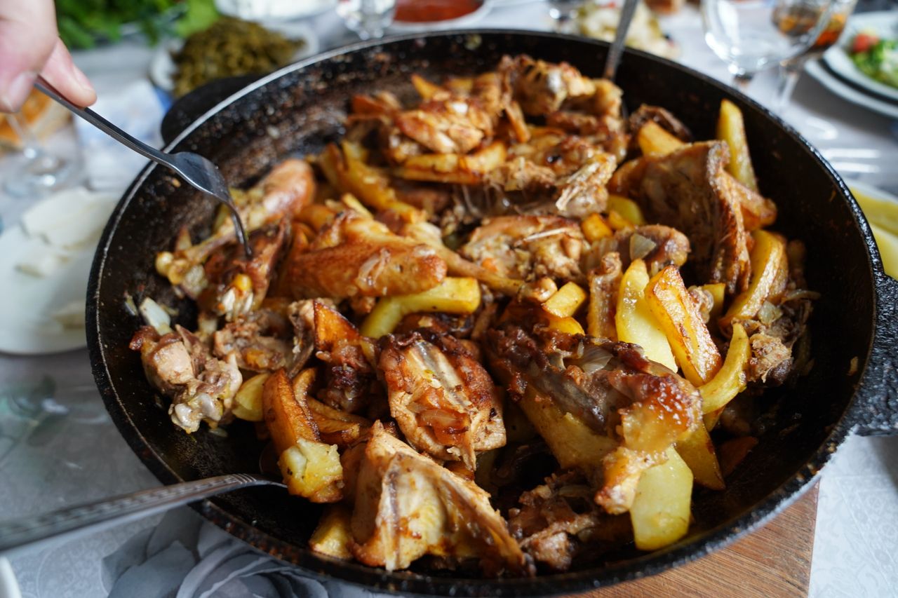 about-01 Savoury roasted chicken and potato dish served in a large skillet, perfect for family gatherings.